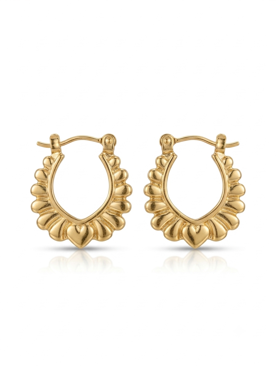 Pair of polished gold oval hoop earrings featuring a scalloped outer rim and a central heart motif on a white studio background.