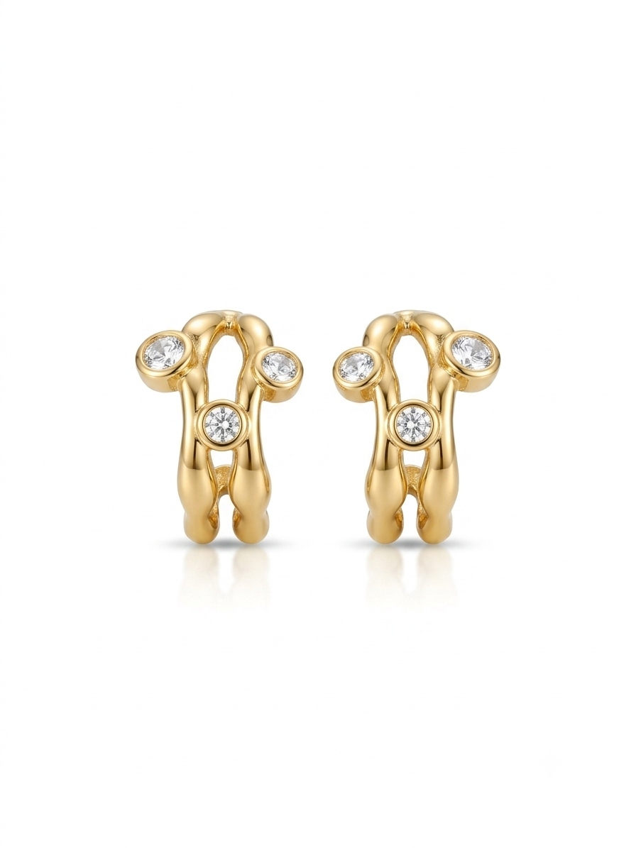 Pair of polished gold sculptural openwork earrings featuring bezel-set round clear stones on a white background.