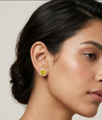 Pair of gold stud earrings featuring yellow cushion-cut center stones surrounded by clear pavé halo borders on a white studio background.