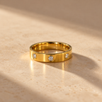 the Trinity Luxe Ring features a polished gold-tone band adorned with three sparkling round stones set in elegant bezel settings.