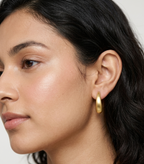 Pair of elongated matte gold teardrop-shaped stud earrings with post backs displayed against a white background.