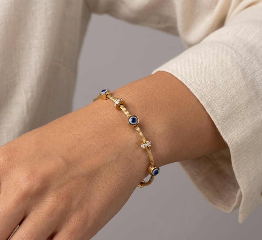 Model wearing Anti-tarnish 18K gold-plated evil eye cable bangle.