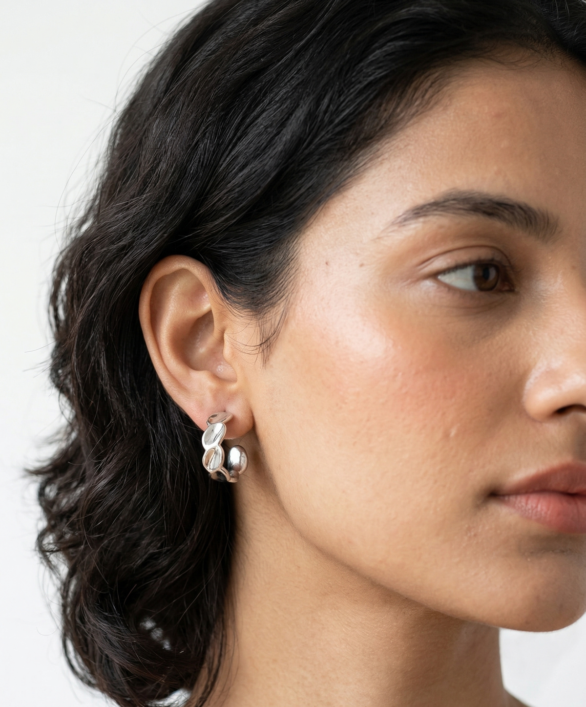 Model wearing Pear-shaped drop earrings with a bezel setting.