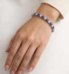 Model wearing Anti-tarnish silver tennis bracelet with deep blue stones.