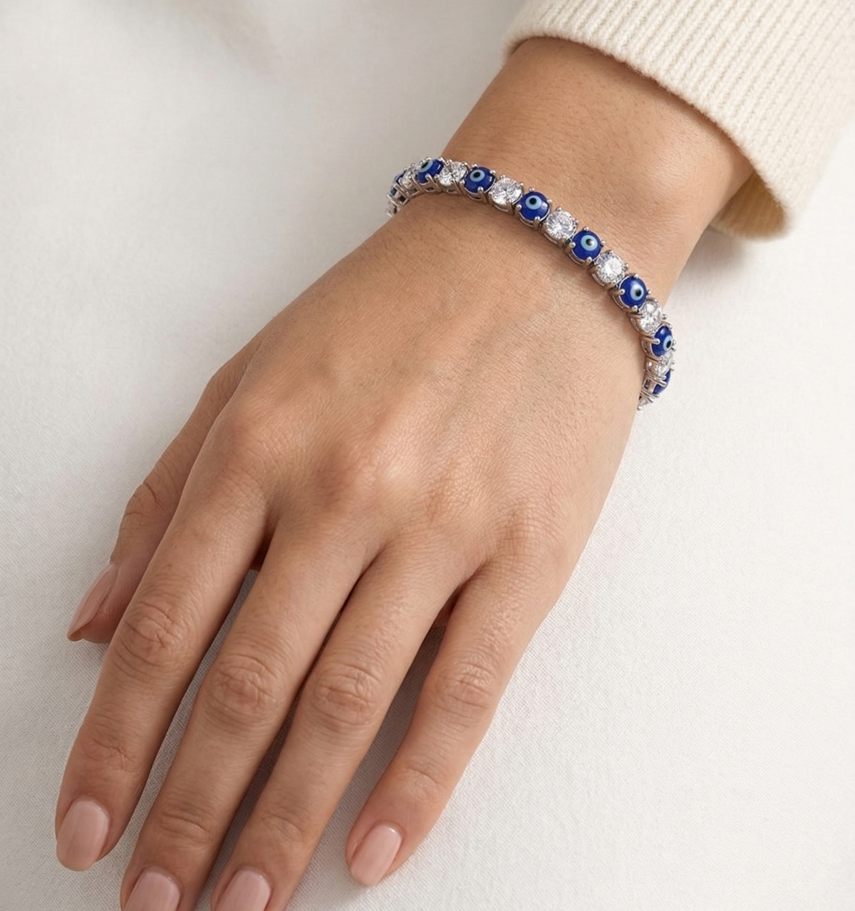 Model wearing Anti-tarnish silver tennis bracelet with deep blue stones.