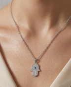 Modle wearing Anti-tarnish silver pavé Hamsa hand evil eye pendant necklace.