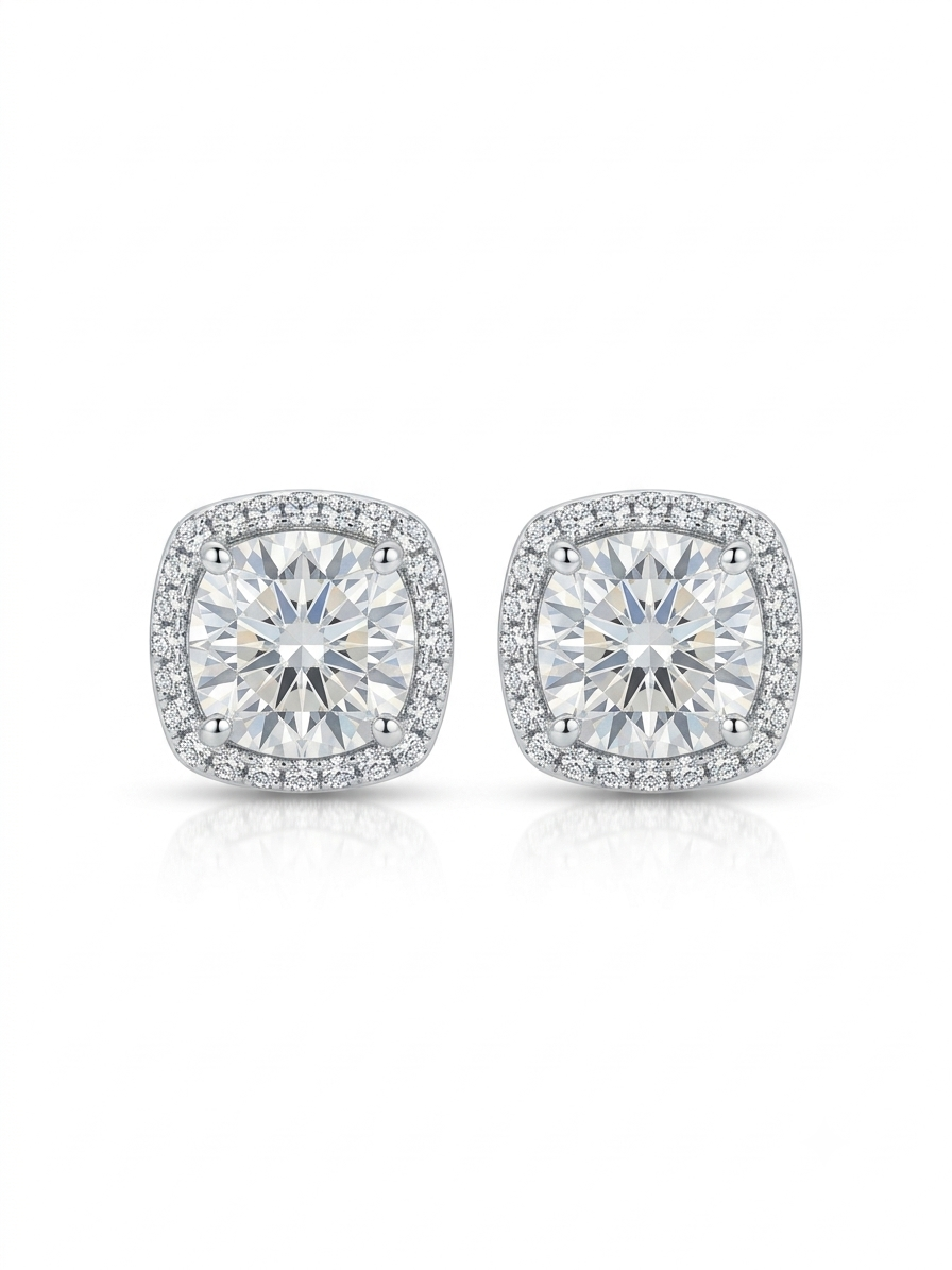 Pair of silver-tone stud earrings featuring round-cut clear gemstones enclosed in a cushion-shaped micropavé halo on a pure white studio background.